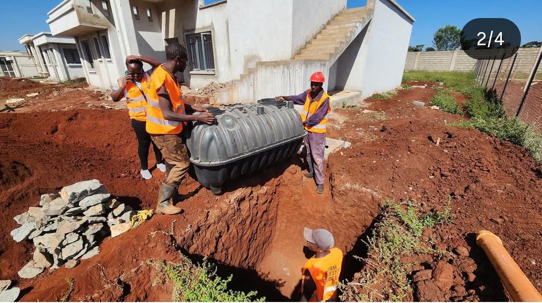 image of an installed plastic biodigester unit in a Kenyan residential compound, ideally showing the tank being lowered into a pit